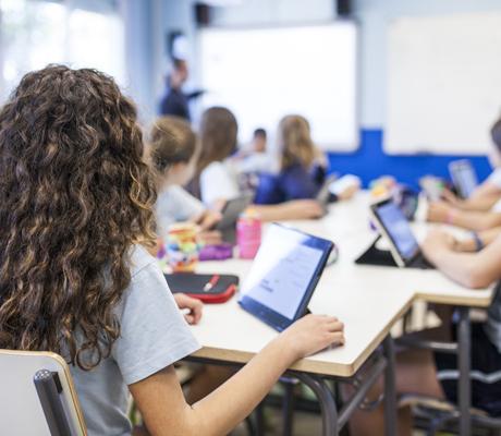Schulkinder in Klassenraum beim Unterricht mit tablets